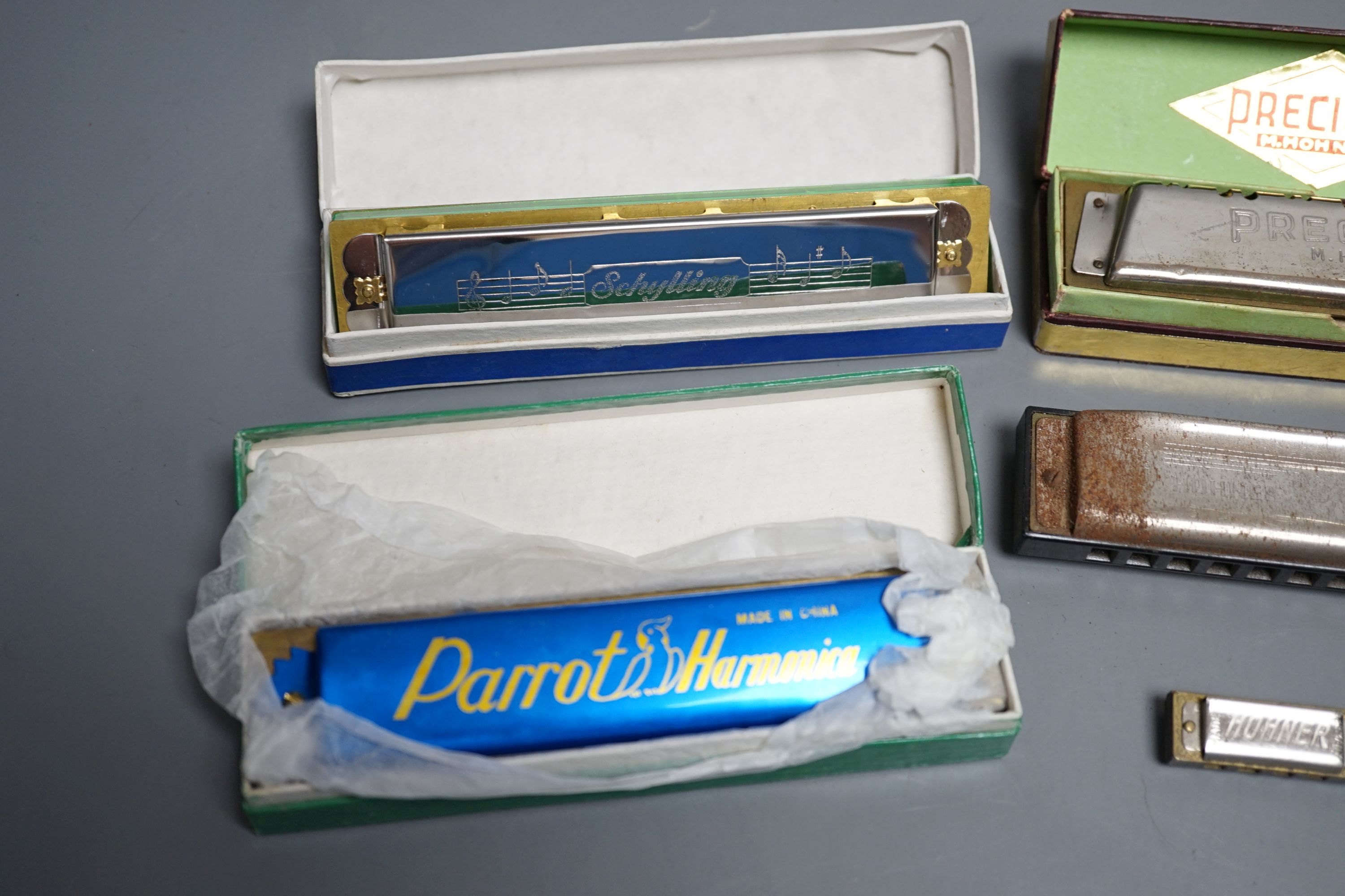 Eight various harmonicas, some with boxes